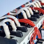 A number of magnetic starters and connected electrical wires in the electrical Cabinet. Cables with tips and digital marking. Red wires are assembled into a bundle of plastic ties.