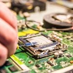 Technical support worker greases with thermal grease paste computer processor