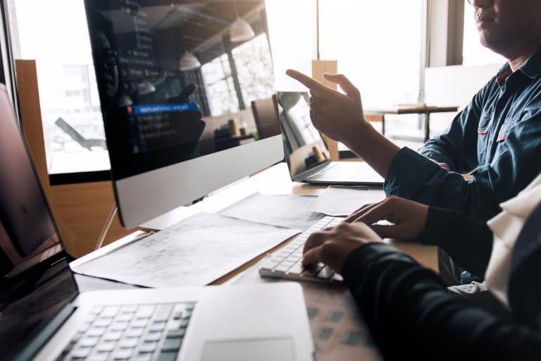 Professional development programmer cooperating meeting programming website working a software in office room.