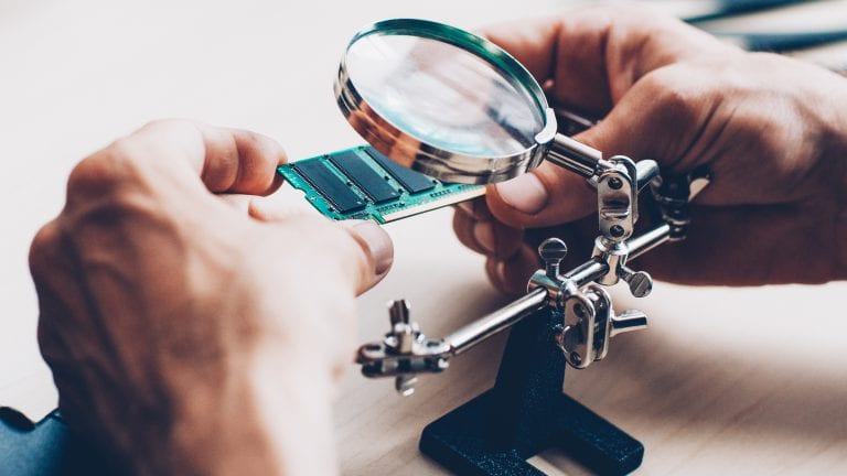 Electronics expertise. Microcircuits, magnifier Technician examining components