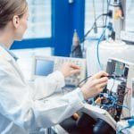 Engineer woman measuring electronic product on test bench in her lab for EMC compliance