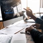 Professional development programmer cooperating meeting programming website working a software in office room.